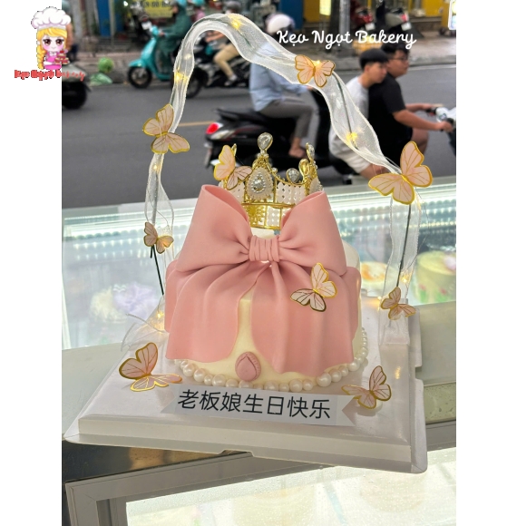 Bánh kem tone hồng trang trí vương miệng và nơ hồng 